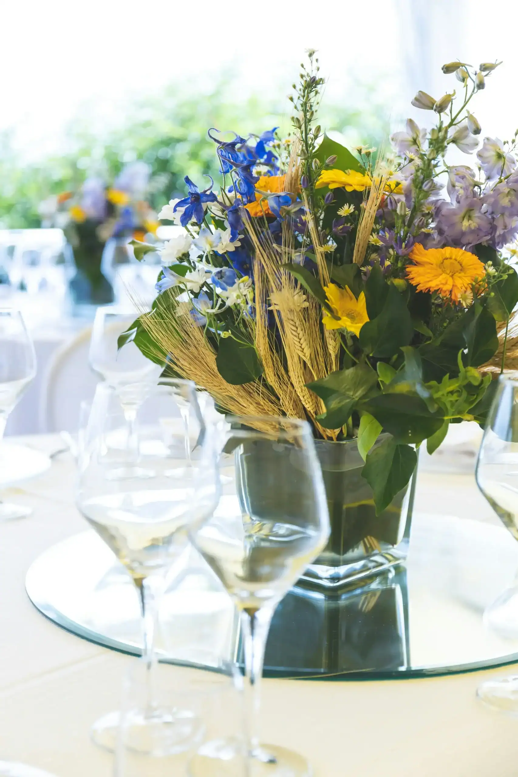 Vibrant flower arrangement featuring yellow, blue, and purple flowers in a glass vase.